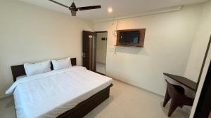 a bedroom with a bed and a television in it at JJ Comfort Hotel in Turuvekere