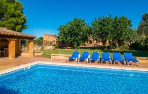 a swimming pool with blue chairs next to a house at Can Moleta in Cala Mendia