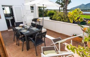 a table and chairs on a balcony with an umbrella at Sa Fornera in Alcudia +29 photos