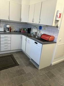 a kitchen with white cabinets and a dishwasher at Nymans pensionat in Aneby