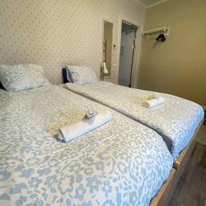 two beds with towels on top of them in a bedroom at Nymans pensionat in Aneby