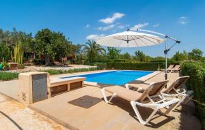 ein Swimmingpool mit zwei Liegestühlen und einem Sonnenschirm in der Unterkunft Ceratonia in Binissalem + 49 Fotos