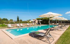 a swimming pool with lounge chairs and umbrellas at Son Capellot Uno in Felanitx +34 photos