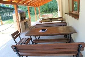 three wooden tables and chairs on a patio at Penzión Gazarka in Šaštín