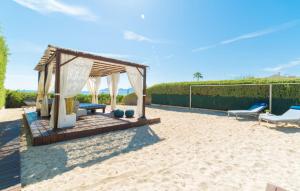 a backyard with a gazebo and chairs on the beach at Sa Platja in Playa de Muro