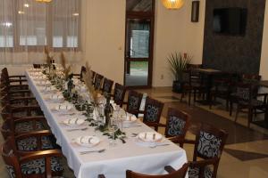 a long table with chairs and a white table cloth at Penzión Gazarka in Šaštín