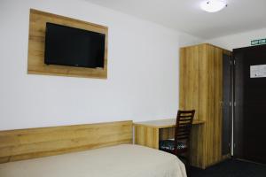 a bedroom with a bed and a desk and a tv at Penzión Gazarka in Šaštín