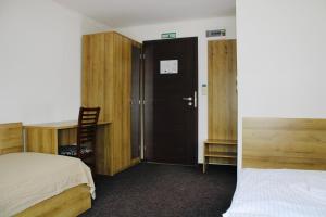 a bedroom with a bed and a desk and a door at Penzión Gazarka in Šaštín +2 photos