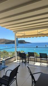 a patio with tables and chairs and a view of the ocean at Mateo Hostel in Himare