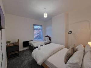 a bedroom with two beds and a television in it at Nice Living Serviced Accommodations 14 in Coventry