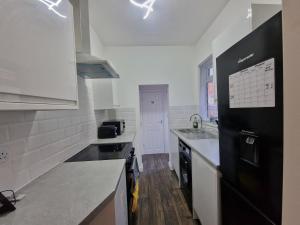 a kitchen with black appliances and a black refrigerator at Nice Living Serviced Accommodations 14 in Coventry