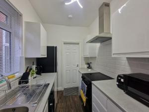 a kitchen with a sink and a dishwasher at Nice Living Serviced Accommodations 14 in Coventry
