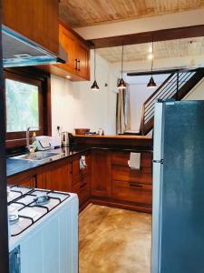 a kitchen with a white refrigerator and a stove at Pilgrims Nature Villa in Ahangama