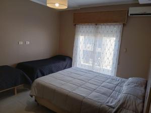 a bedroom with a bed and a window at LOS Teros dptos 3 5 3 4 0 9 2 8 1 5 in Villa María