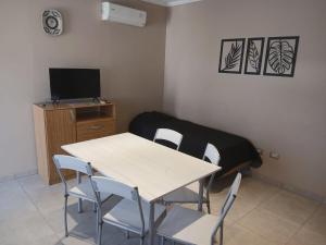 a room with a table and chairs and a television at LOS Teros dptos 3 5 3 4 0 9 2 8 1 5 in Villa María