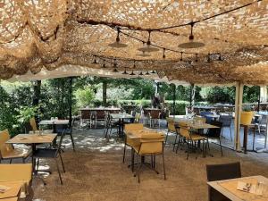 a restaurant with tables and chairs and lights at Valterra Lodges à Châtillon-en-Diois in Châtillon-en-Diois