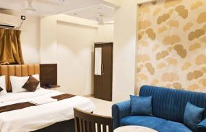 a hotel room with a bed and a blue couch at The Lotus in Pune