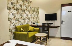 a living room with a green couch and a chair at The Lotus in Pune