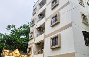 a tall white building with a sign on it at The Lotus in Pune