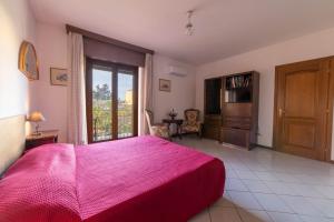 a bedroom with a large bed with a red blanket at Casa Wanda IL MIRTO in Oristano