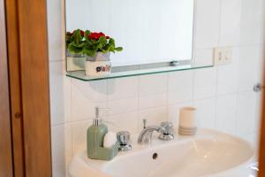a bathroom sink with a green soap dispenser on it at Casa Wanda IL MIRTO in Oristano +23 photos