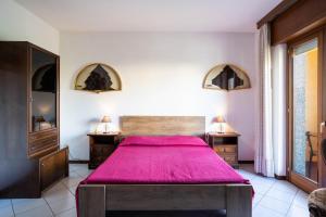 a bedroom with a large bed with a red blanket at Casa Wanda IL MIRTO in Oristano