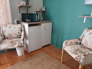 a living room with two chairs and a tv at 7th Heaven Guest Unit in Paarl +4 photos