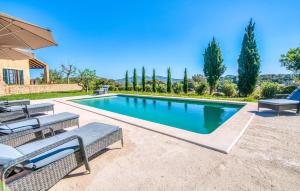 a swimming pool in a yard with chairs and trees at Esteva in Sant Llorenç des Cardassar