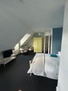 a bedroom with a white bed and a yellow cabinet at Morlea Guest House in Llandudno
