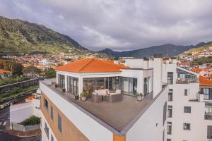 a view of a house with a roof at Beachfront Penthouse with Panoramic Ocean-View Terrace VIP Baia in Machico