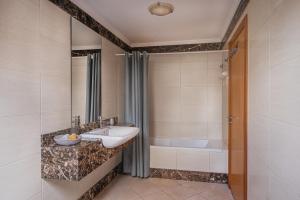 a bathroom with a sink and a bath tub at Beachfront Penthouse with Panoramic Ocean-View Terrace VIP Baia in Machico +32 photos