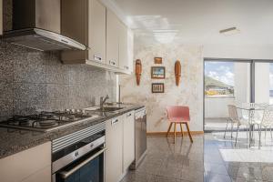 a kitchen with a sink and a stove top oven at Beachfront Penthouse with Panoramic Ocean-View Terrace VIP Baia in Machico