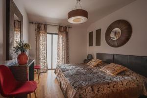 a bedroom with a bed and a chair and a mirror at Beachfront Penthouse with Panoramic Ocean-View Terrace VIP Baia in Machico