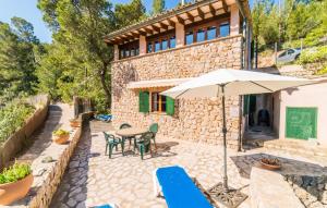 an external view of a stone house with a table and an umbrella at Antonio in Deia