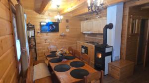 a kitchen with a table and a tv in a cabin at Chata vo dvore in Osturňa