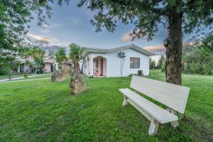 a white bench sitting in the grass in front of a house at Charme in Solèminis +5 photos