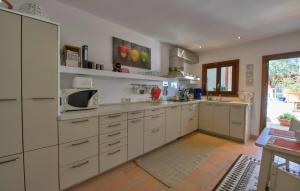 a large kitchen with white cabinets and a microwave at Maria Angela in Artá