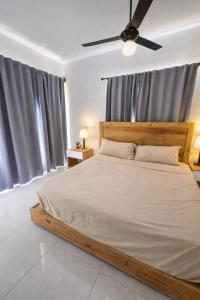a bedroom with a bed and a ceiling fan at Ivy Villa Cabarete, fully equipped villa in Cabarete