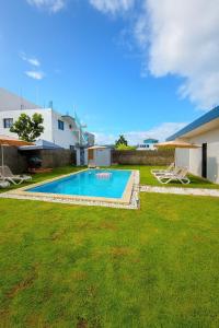 a swimming pool in a yard with two lawn chairs at Ivy Villa Cabarete, fully equipped villa in Cabarete
