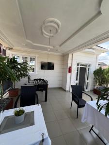 a screened porch with a television and a table and chairs at Trevors Home Place in Lagos