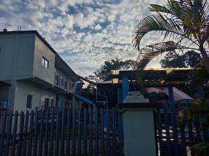 a fence in front of a building with a palm tree at D Grand Charlton in Cattle Landing