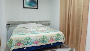 a bedroom with a bed with a floral bedspread at D Grand Charlton in Cattle Landing