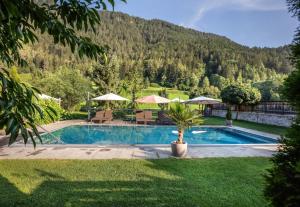 a swimming pool with a mountain in the background at Hotel Riederhof- Urlaub mit WAU! in Ried im Oberinntal