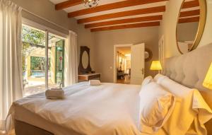 a bedroom with a white bed and a large window at Casa Maria in Santa Maria del Camí