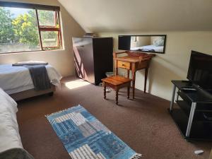 a bedroom with a bed and a desk and a mirror at Mackenzies Accommodation in East London