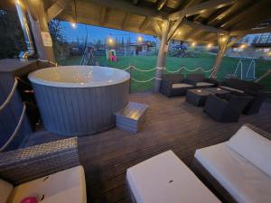 a large tub sitting on a deck with a playground at Góralski Przystanek Jacuzzi & sauna - dom dla 17 osób in Biały Dunajec