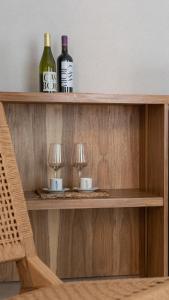 two bottles of wine and two glasses on a shelf at Casa Bora Hotel Boutique in San Antonio de Areco