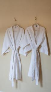 two white robes are hanging on a wall at Casa Bora Hotel Boutique in San Antonio de Areco