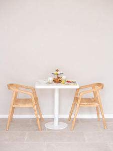 a table with two chairs and a table with food on it at Casa Bora Hotel Boutique in San Antonio de Areco +19 photos