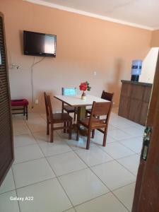 a dining room with a table and chairs and a tv at Apartamento Aconchegante 1 quarto in Crato